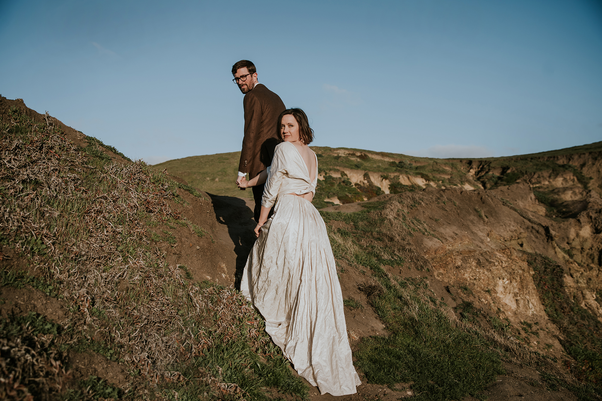 Climbing up the cliff side during their Point Reyes elopement.