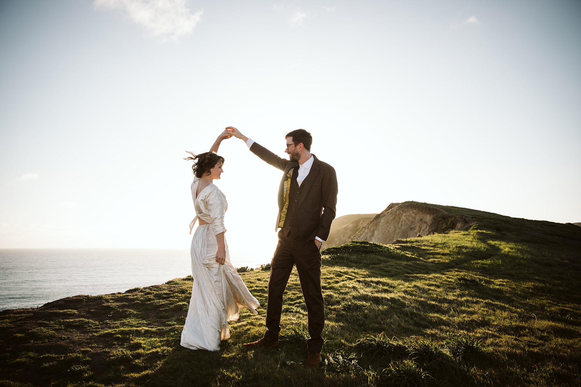 Groom twirling bride in the sunset during their Point Reyes elopement.