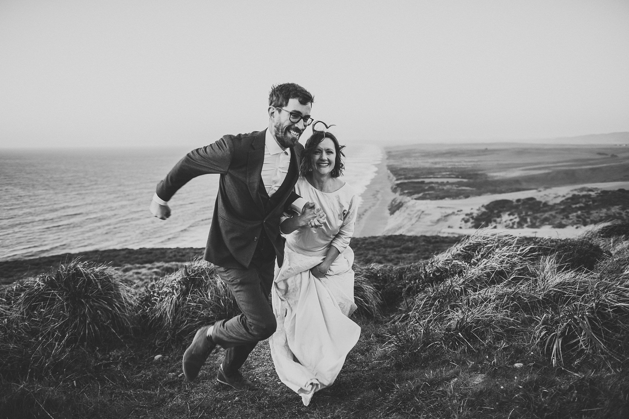 Bride and groom run to their car to get warm at the end of their Point Reyes elopement.