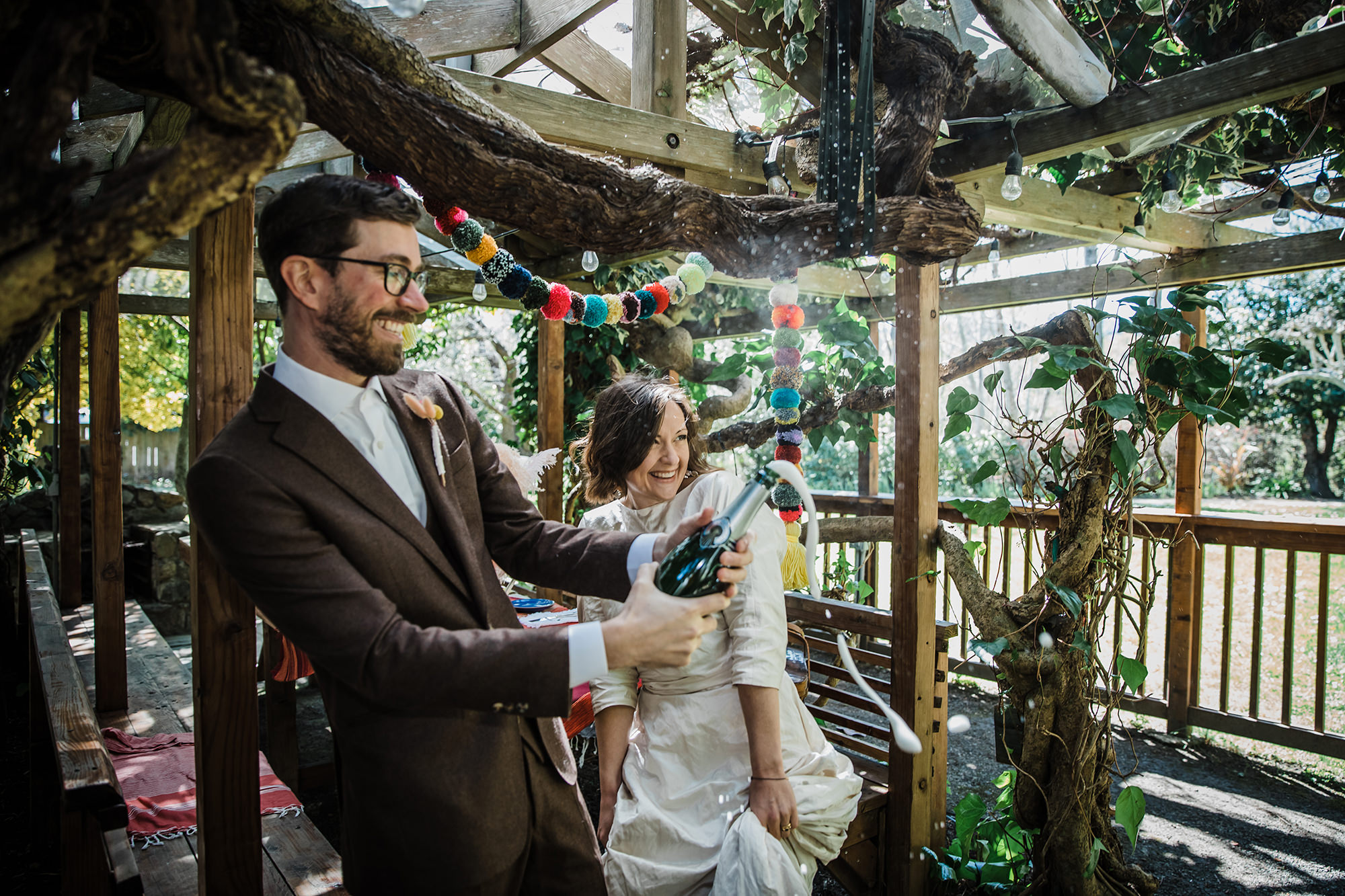 Bride and groom celebrate with a bottle of champagne for Point Reyes elopement at Olema House.
