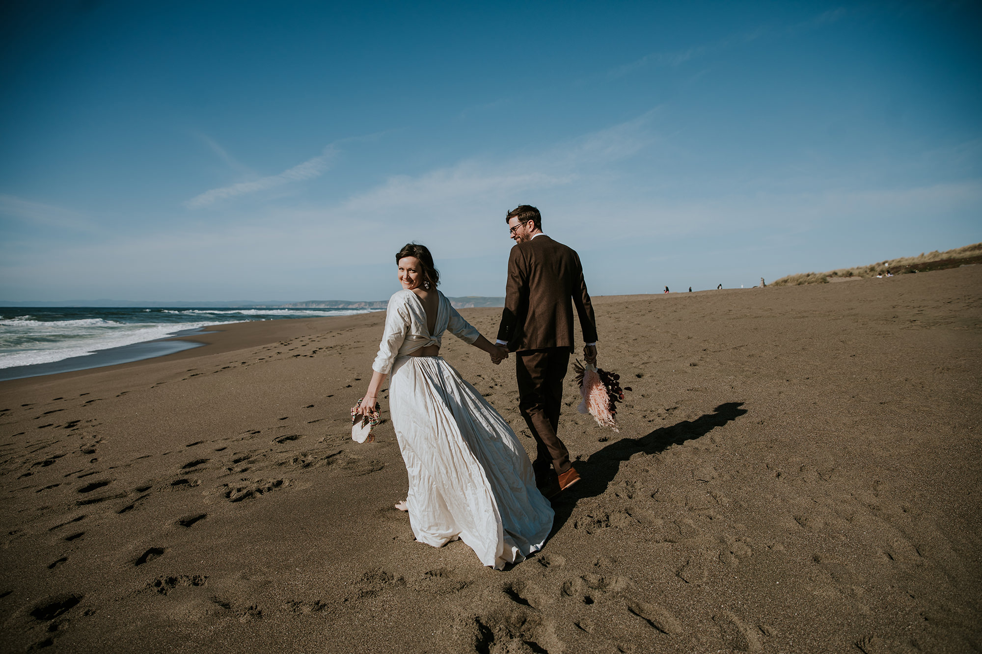 Bride and groom running along beach for Point Reyes Elopement