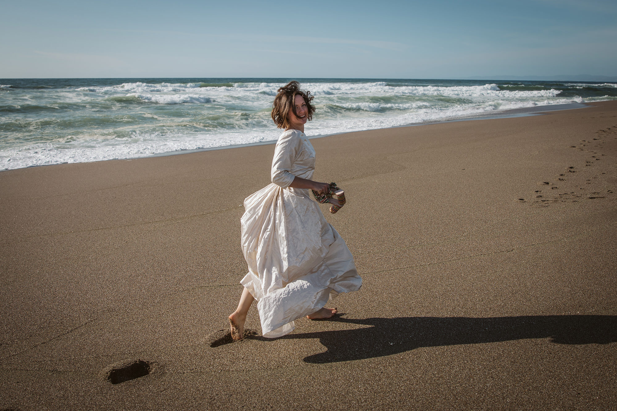 Bride playing on beach for Point Reyes Elopement.