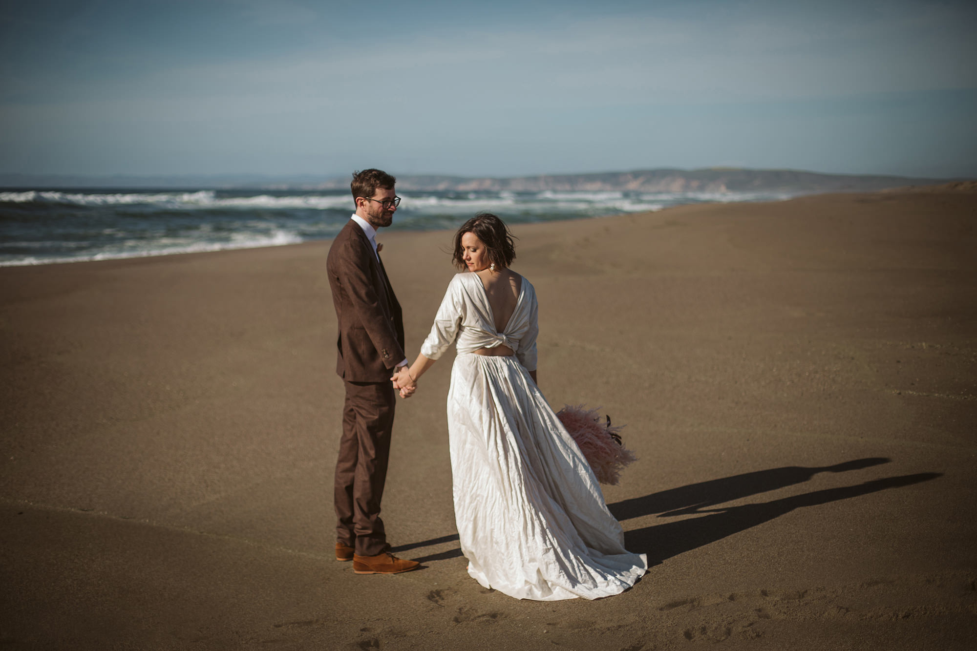 Bride and groom holding hands on beach for Northern California Elopement