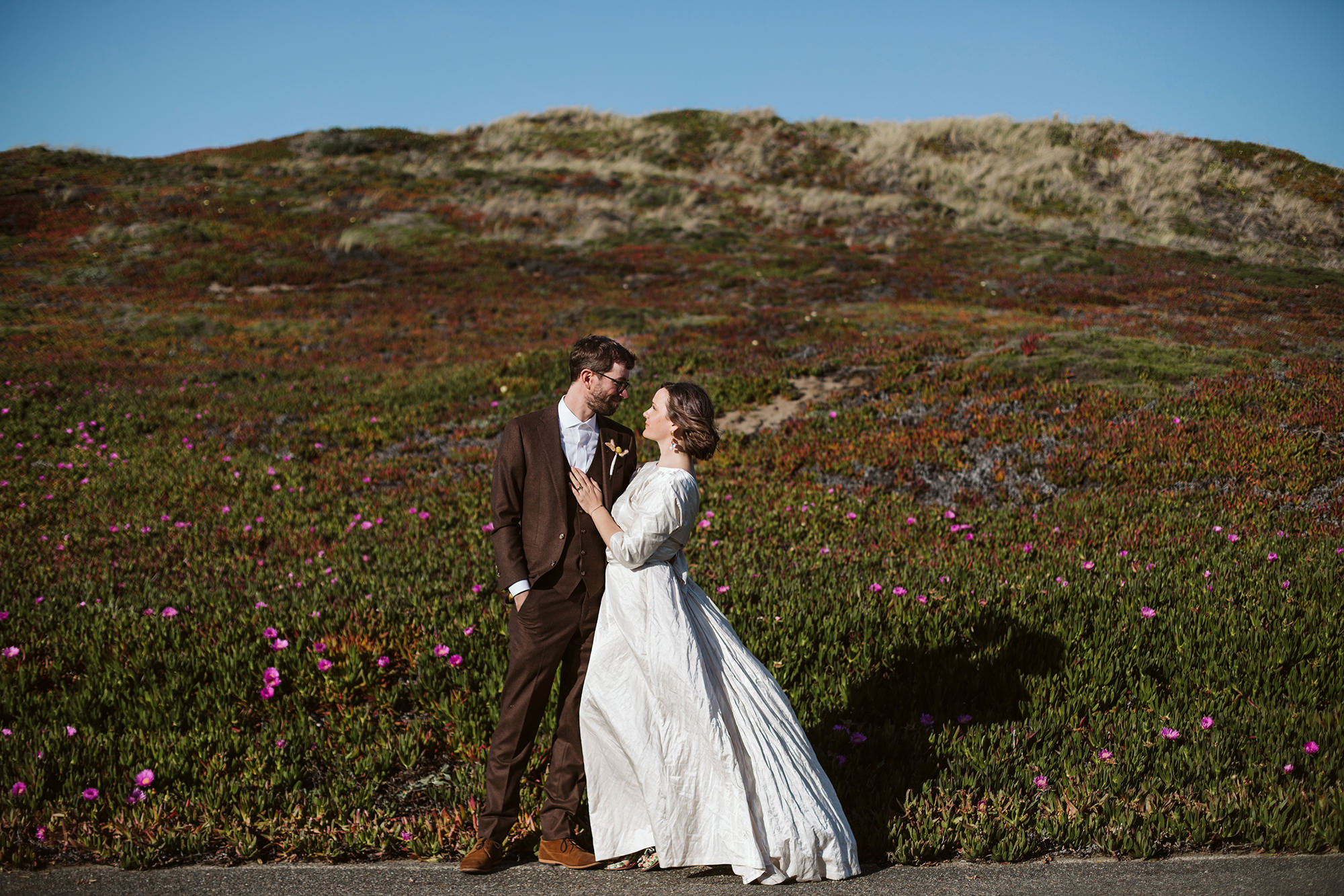 Bride looks into eyes of groom in front of field of succulents at sunset for Point Reyes Elopement.