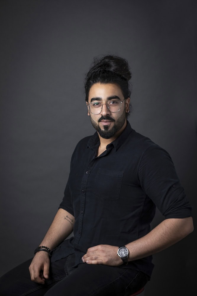 Professional headshot of a confident man with glasses for branding website.
