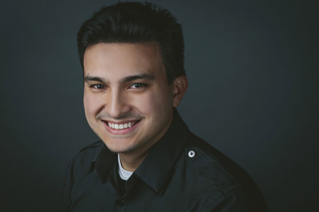 Smiling professional headshot of a young man for branding and corporate profile use.