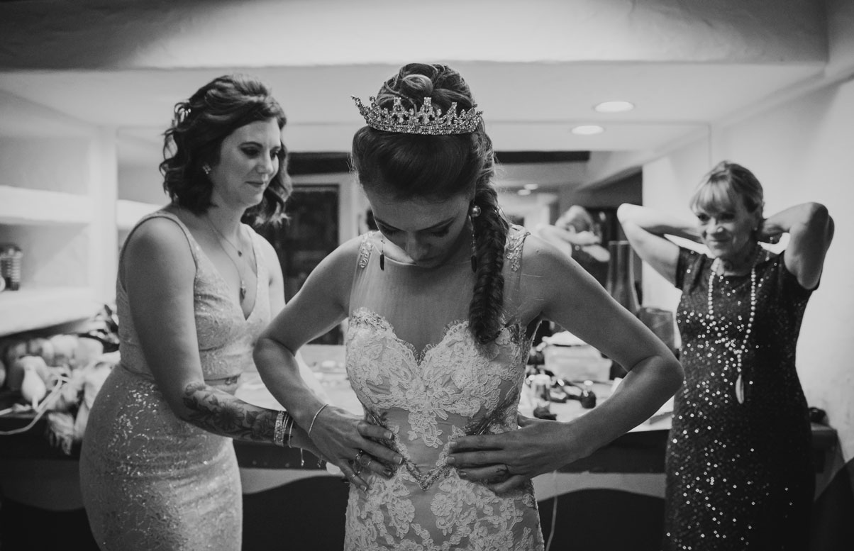 Bride putting on dress before the ceremony at a Carmel Wedding.Becca Henry Photography