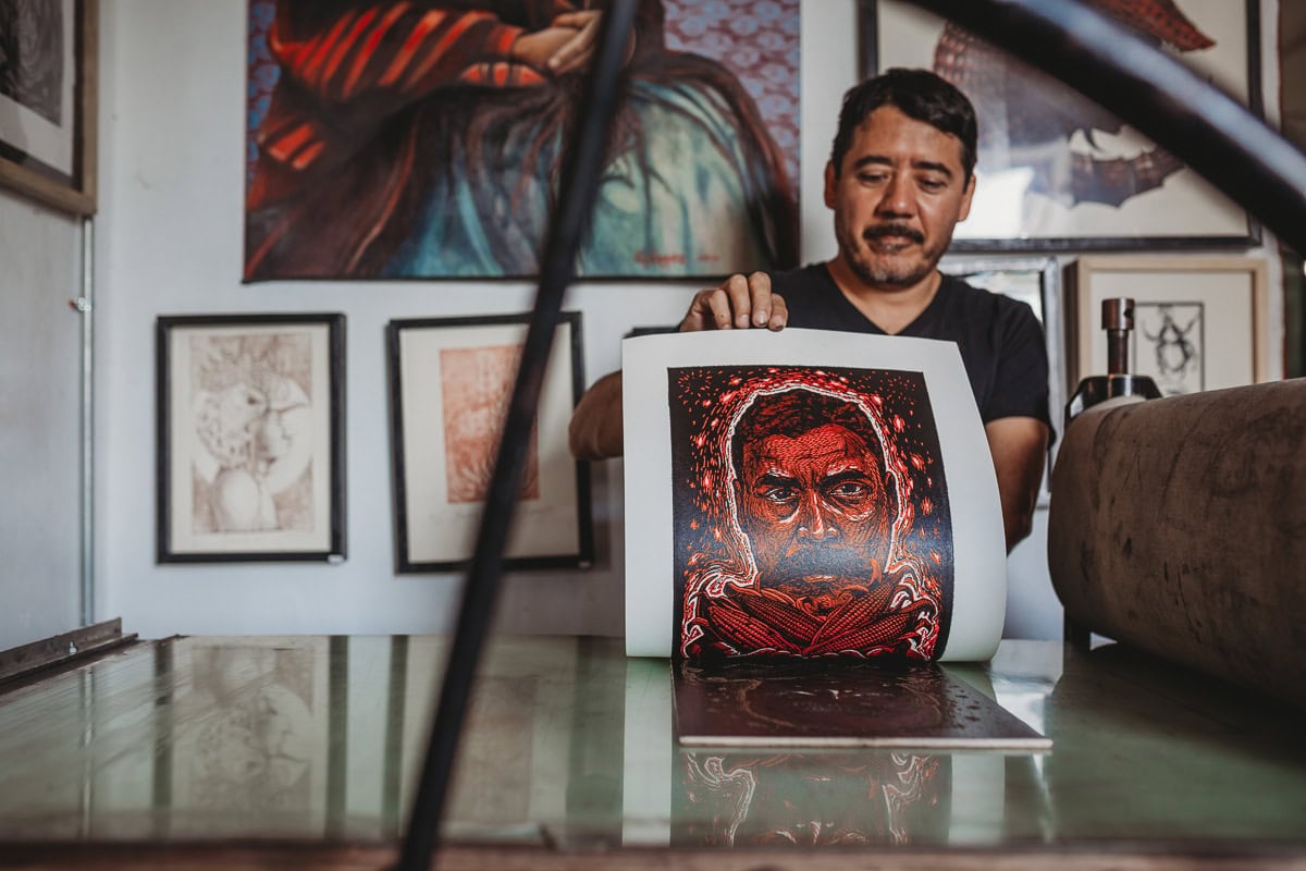 Portrait of artist holding artwork in studio