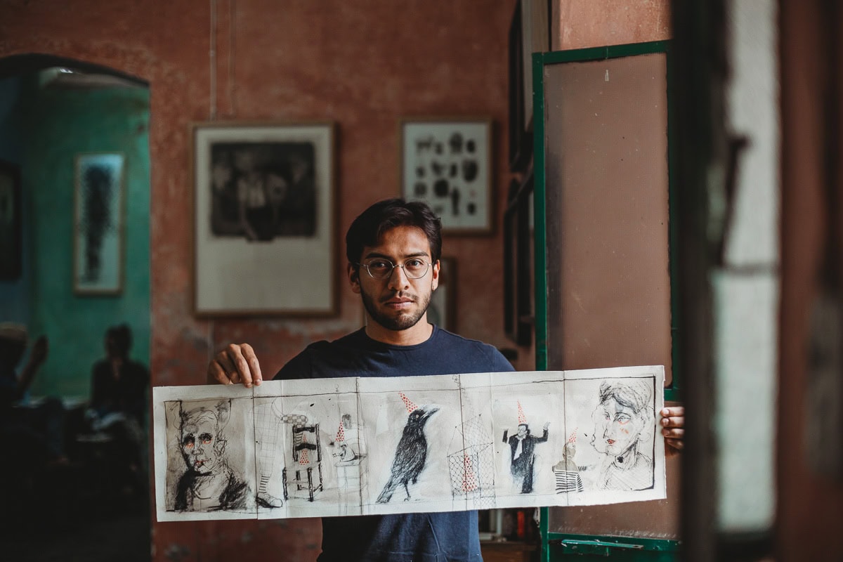 An artist displaying his sketches and artwork in a vibrant, artistic studio environment.- Artist Branding Photography in Mexico