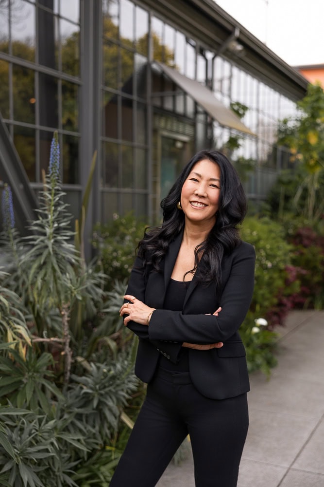 Confident businesswoman smiling outside in professional attire.