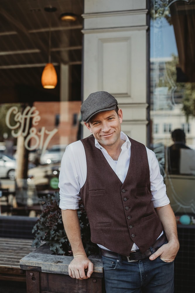 Man in stylish vest and cap smiling outdoors for professional branding photography in Oakland, CA