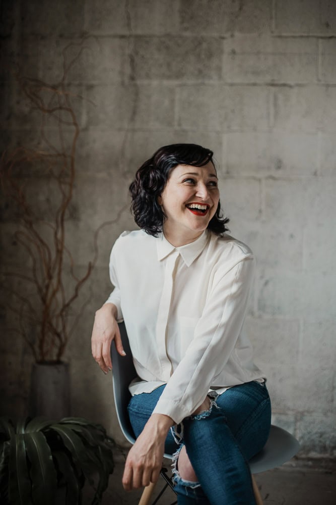 Woman smiling in a modern office setting for branding website.