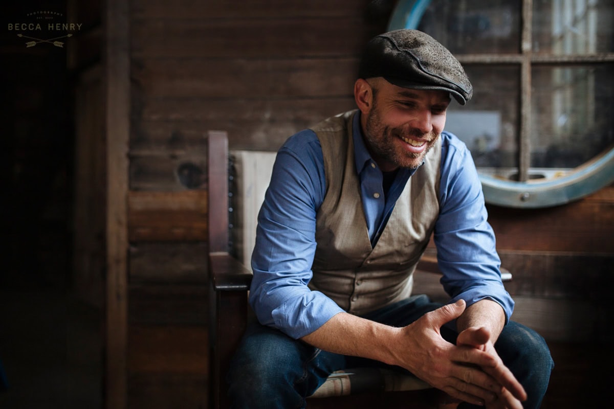 Smiling man in casual attire with vintage background for branding photography.