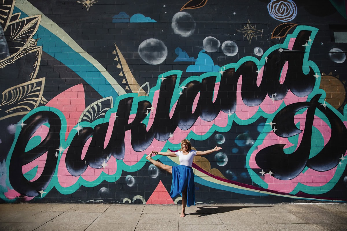 Colorful Brooklyn street art featuring a woman dancing in front of a large mural.