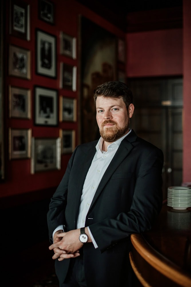 Professional portrait of a an opera singer in a suit at a stylish bar setting. Branding photography for his new website