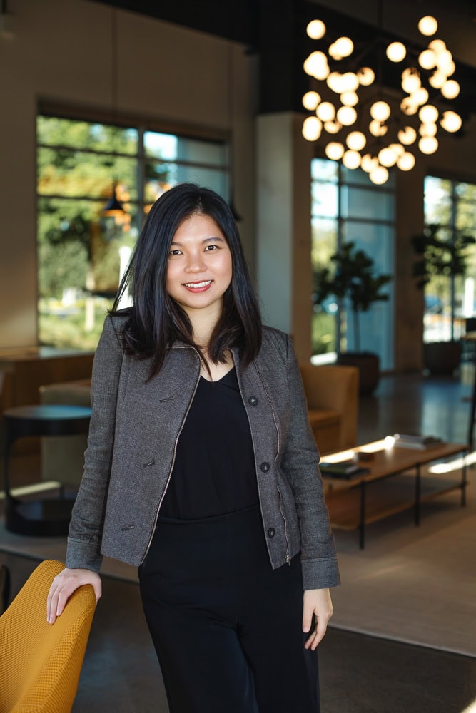 Professional woman in modern office with warm lighting and contemporary decor.