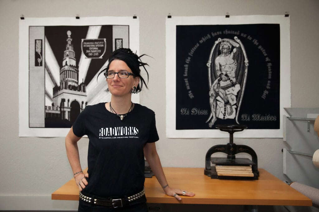 Woman standing in art gallery with black and white artwork behind her. Branding Photography