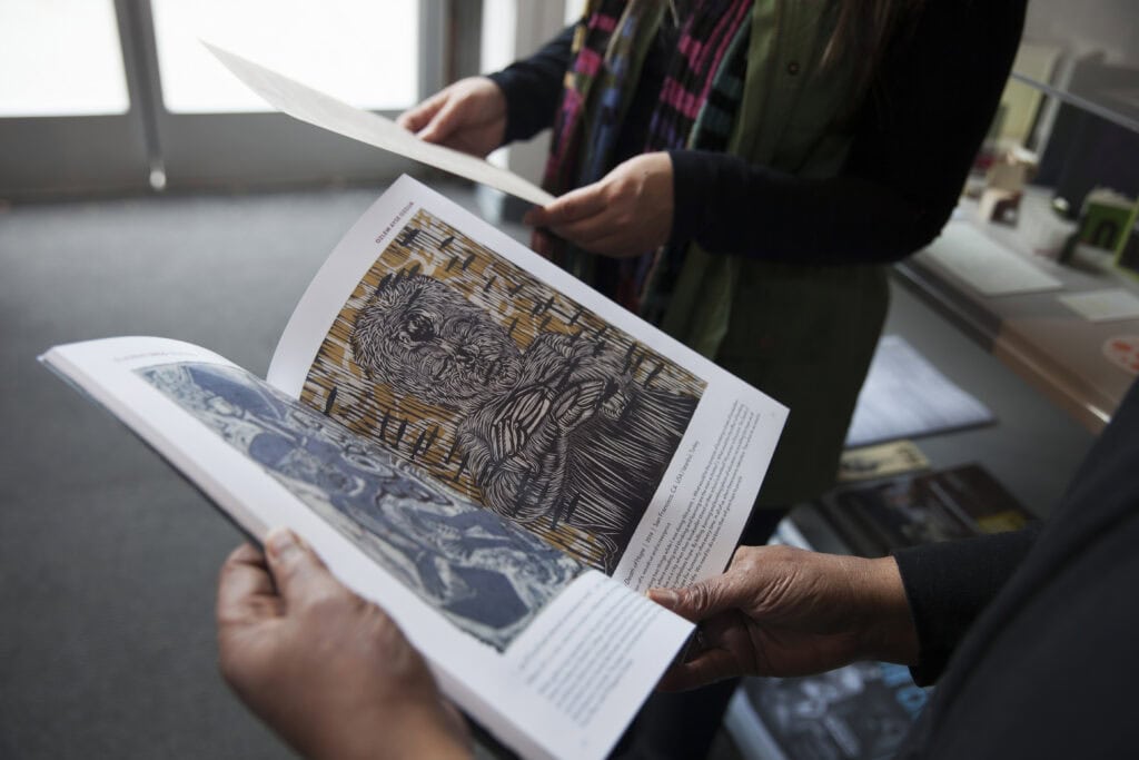 People reviewing printed artwork.  Becca Henry Branding photography for San Francisco Center for the Book 