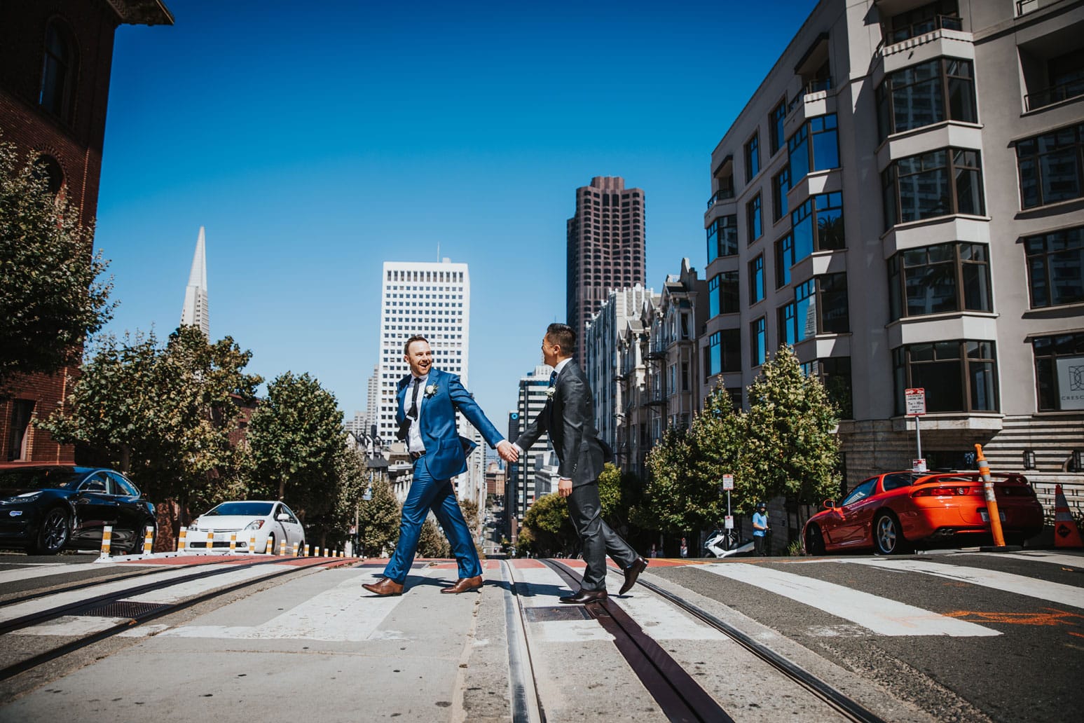 San Francisco cityscape with two businessmen in suits crossing the street.