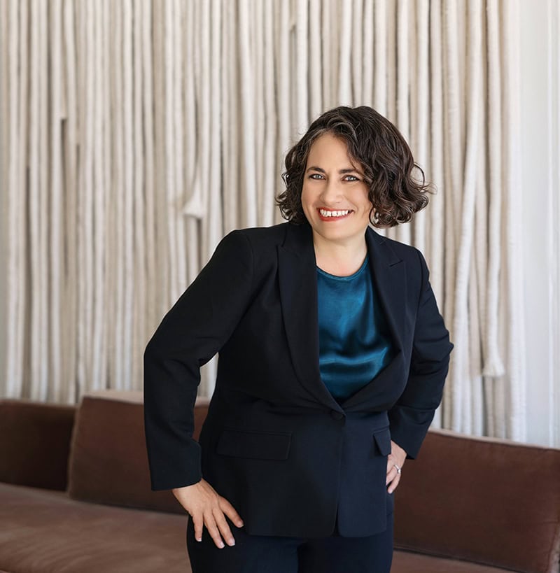 Professional woman in business suit smiling for branding photoshoot.