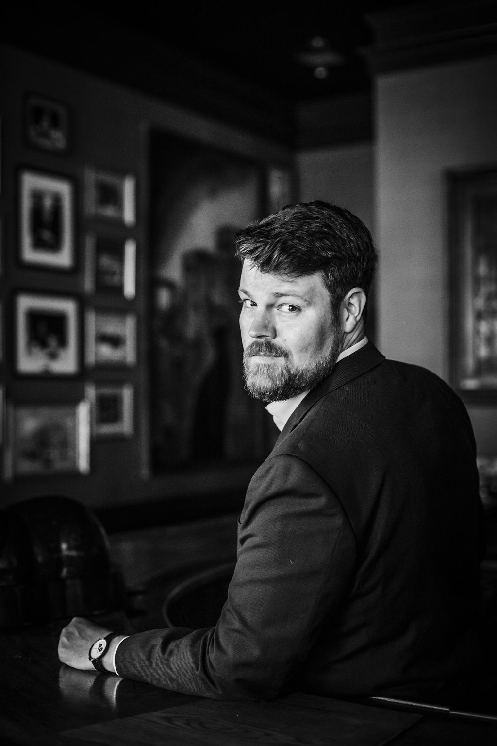Professional man in a suit at a modern office, showcasing branding and corporate identity.